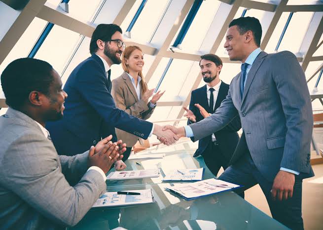 Socios de negocios dándose la mano en una reunión